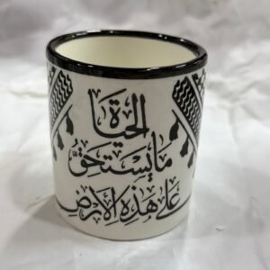 كوب خزف مزخرف بعبارة (علَى هَذِهِ الأَرْض مَا يَسْتَحِقُّ الحَياةْ)